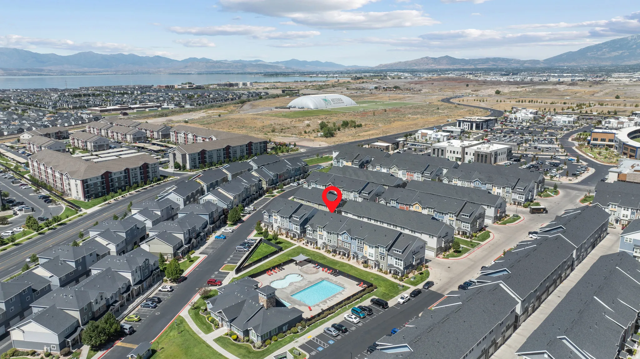 Community with multi-story residences, communal swimming pool, and dedicated parking areas