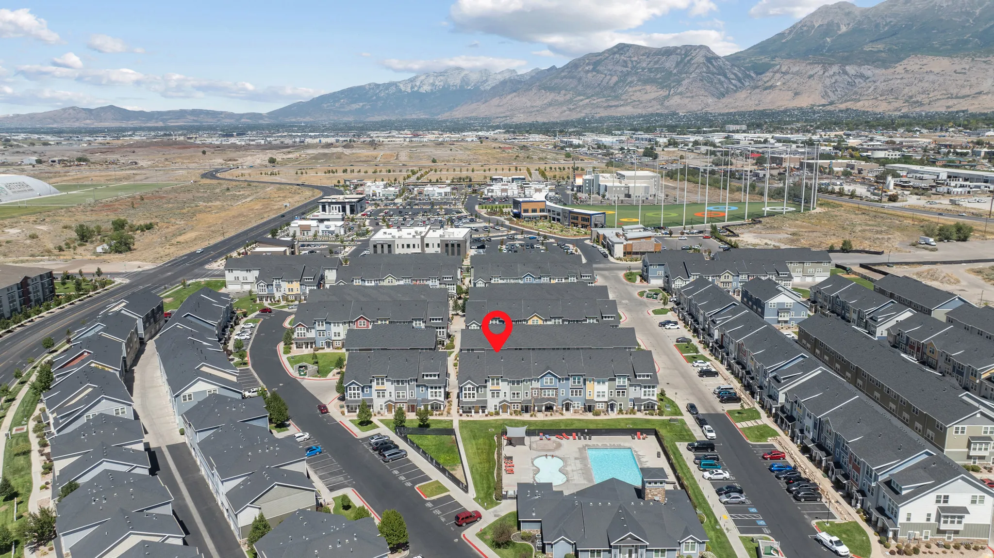 Townhome community featuring multi-level residences, an outdoor swimming pool, and dedicated parking
