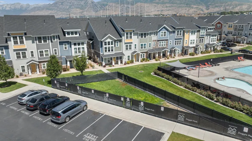 Community featuring a swimming pool, shaded lounge area, and a fenced green space