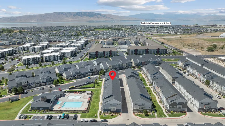 Aerial perspective of a multi-unit residential development with a community pool and adjacent clubhouse