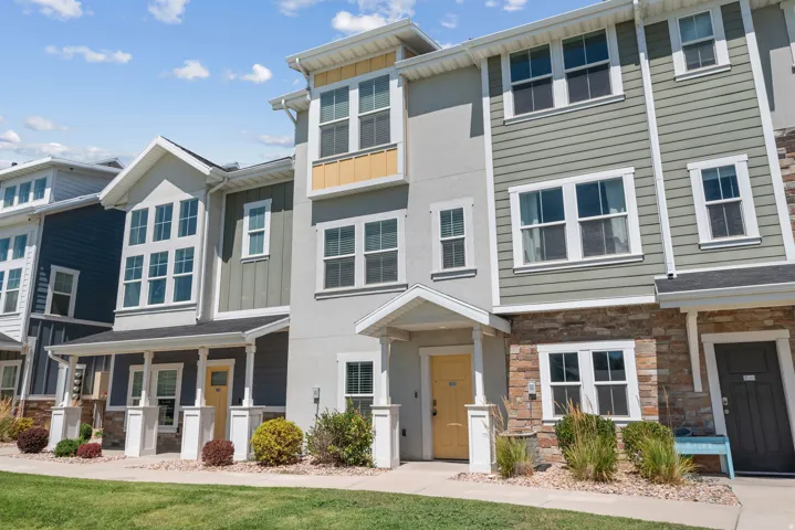 Modern multi-level exterior with varied siding, stone accents, and covered entryways