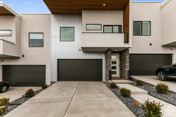 Modern facade featuring a balanced mix of textured stucco, corrugated metal siding, wood paneling, and stone accents