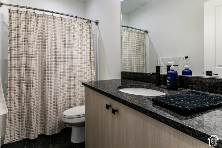 Integrated vanity with a dark speckled cohttps://www.utahrealestate.com/lip.wizard/run/step/2/hbid/5521041#untertop, undermount sink, and matte black faucet
