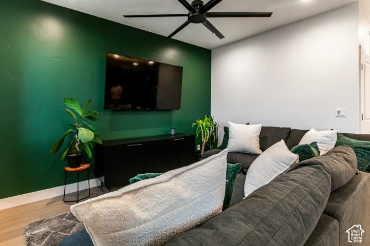 Accent wall, recessed lighting, matte black ceiling fan, wood-finish flooring, built-in media console