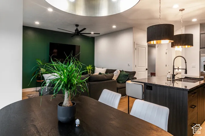 Open-concept living space featuring recessed lighting, a ceiling fan, a kitchen island with seating, and pendant lighting