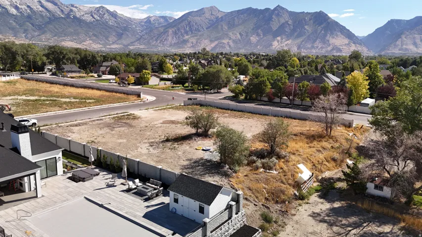 Expansive lot featuring a pool, surrounding patio, and a separate structure with a dark roof