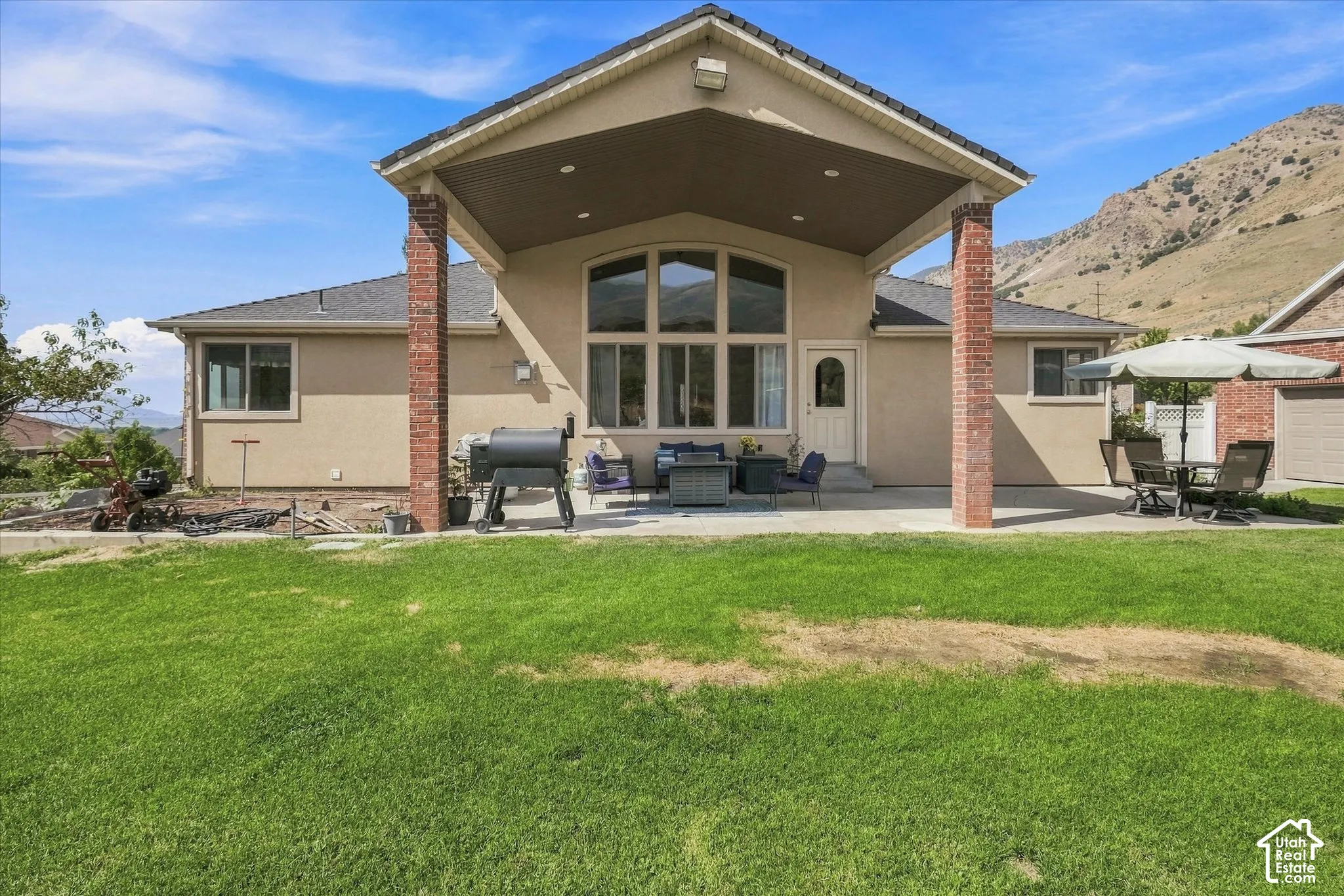 Expansive concrete patio with brick support columns, offering a covered outdoor living area