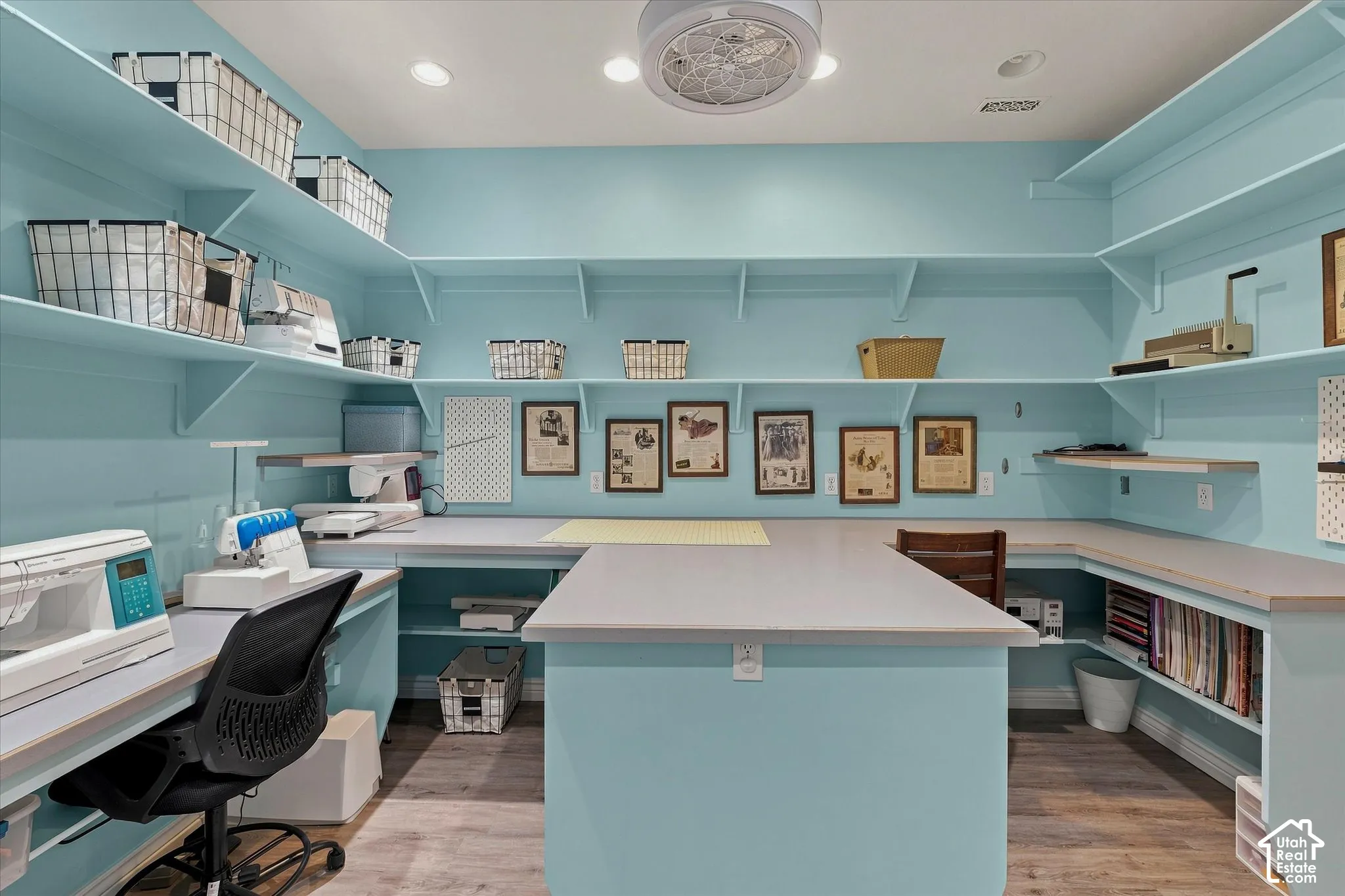 Extensive built-in shelving, ample countertop space, central work island, recessed lighting, and wood-finish flooring
