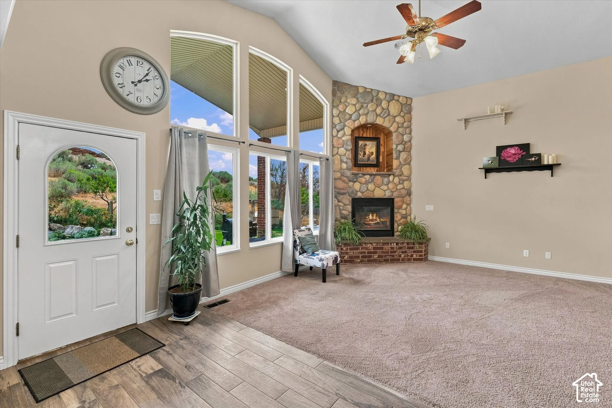 Vaulted ceilings, a stone-clad fireplace with brick hearth, and arched windows
