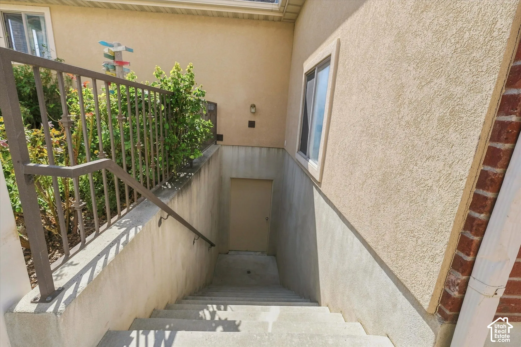 Stucco exterior with concrete stairs and metal railing