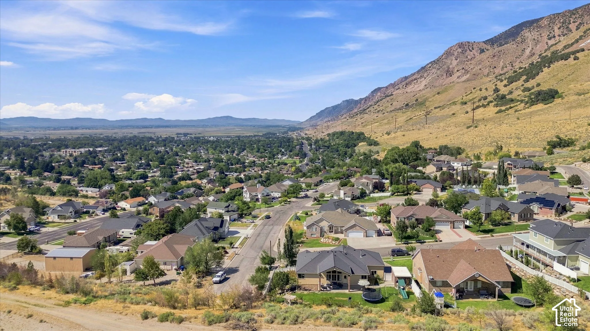 Expansive residential area with a prominent mountainous backdrop and a distant treeline