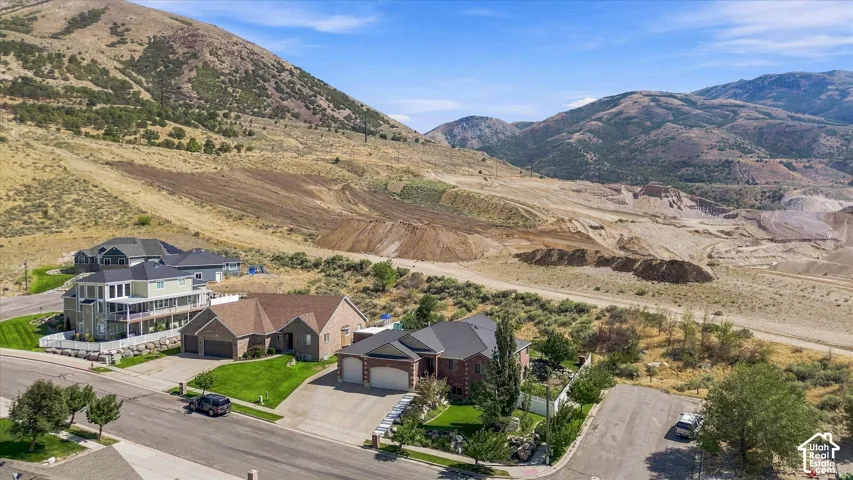 Mountain backdrop, residential street, and multiple properties with landscaped yards