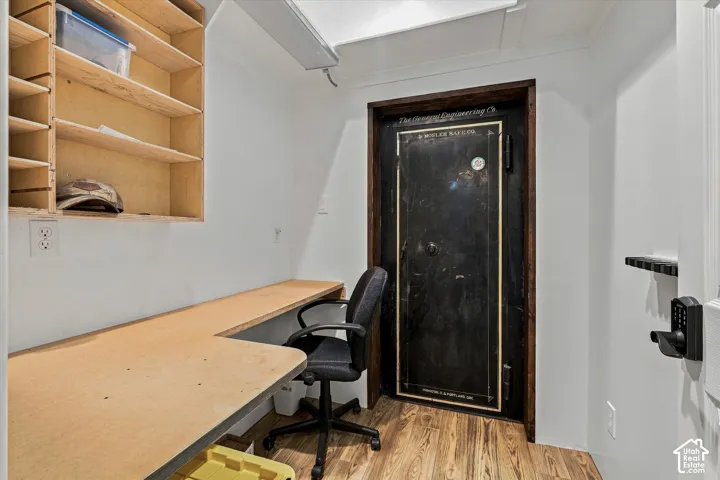 Built-in shelving, expansive built-in desk, wood-finish flooring, and a robust safe door