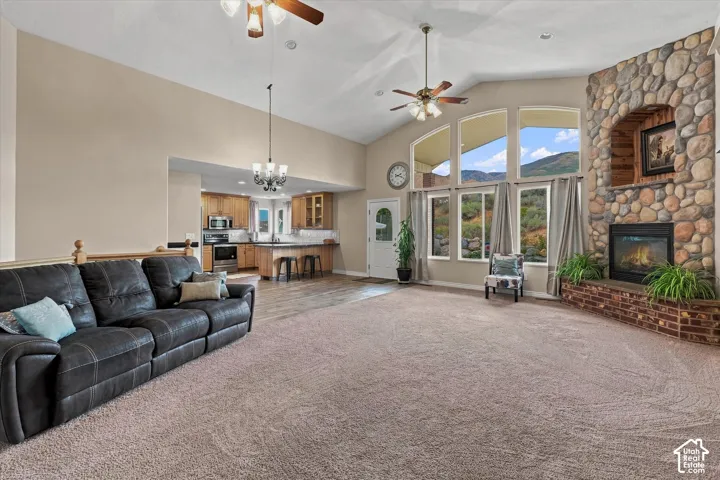 Vaulted ceilings, a stone-faced fireplace with a brick hearth, and multiple large windows