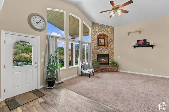 Vaulted ceilings, a stone-clad fireplace with brick hearth, and arched windows