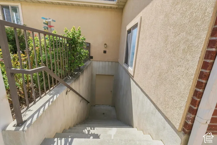 Stucco exterior with concrete stairs and metal railing