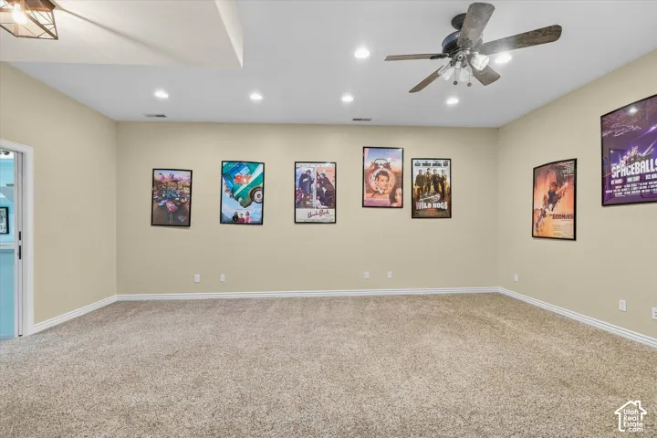 Recessed lighting, ceiling fan, and plush carpet flooring