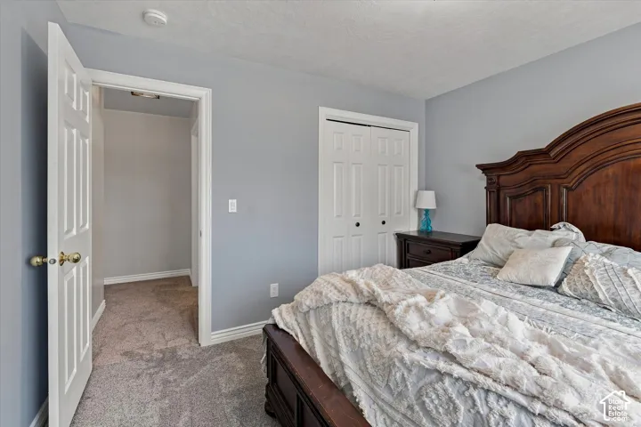 Carpeted flooring, paneled interior doors, and a closet with bi-fold doors