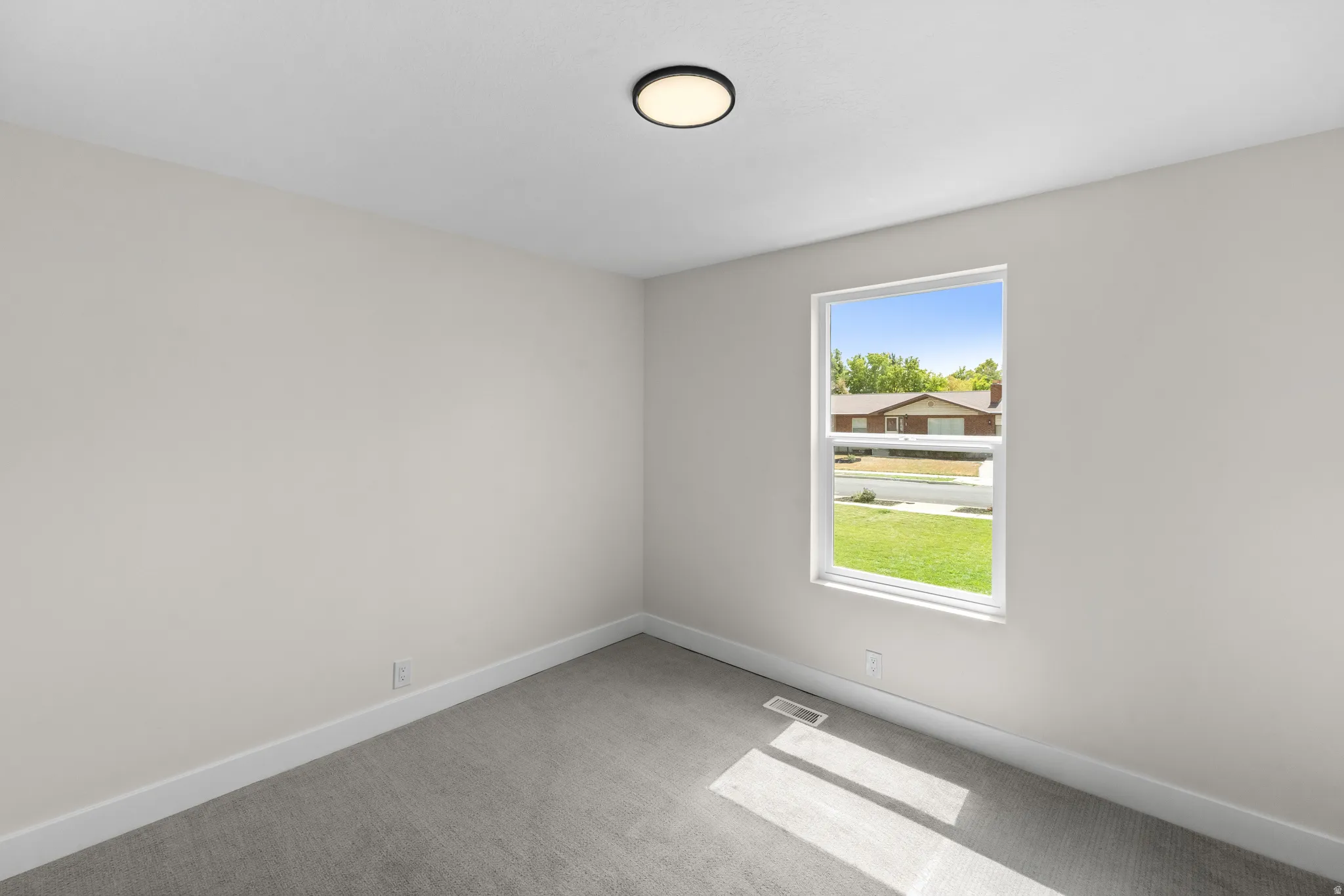 Recessed lighting, light gray carpet, and a large window