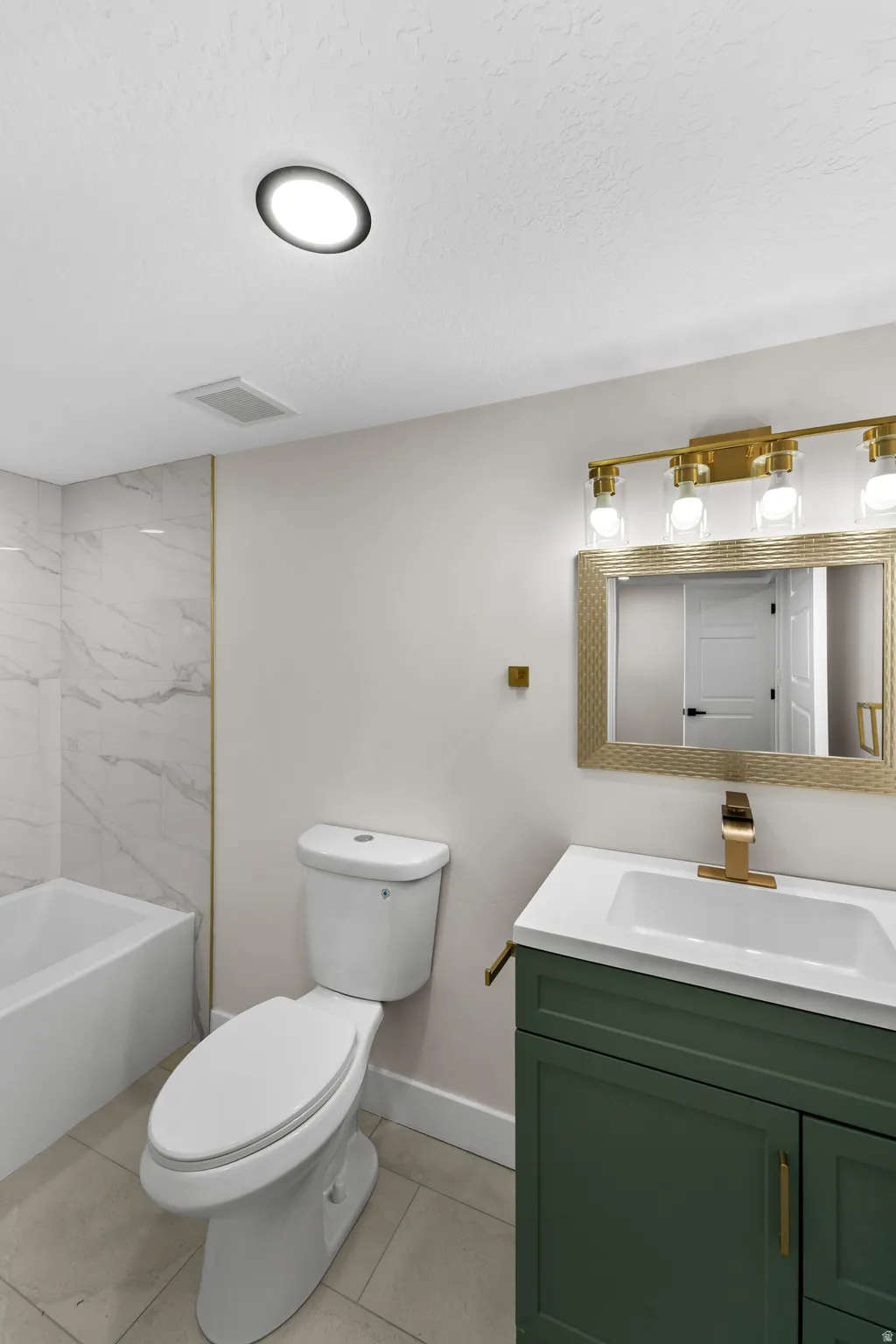 Vanity with a green finish, gold-toned faucet, and rectangular sink