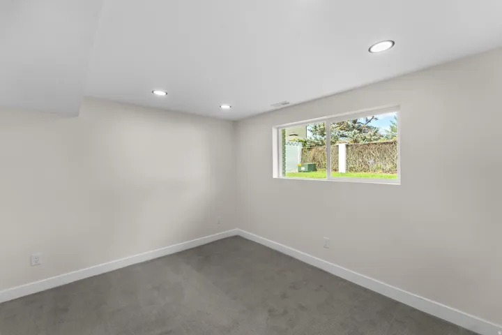 Recessed lighting, light gray carpet, and a large window