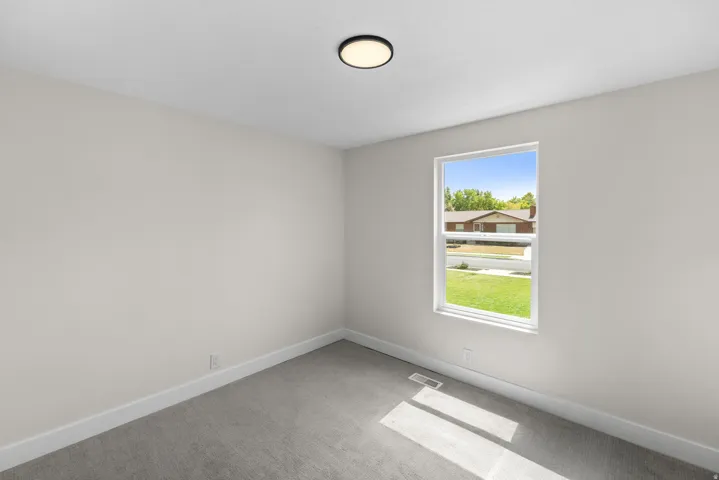 Recessed lighting, light gray carpet, and a large window