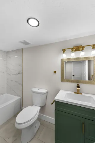 Vanity with a green finish, gold-toned faucet, and rectangular sink