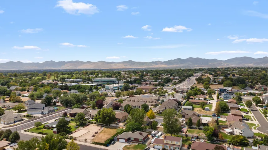 Sprawling community with mature trees, established residential areas, and mountain backdrop
