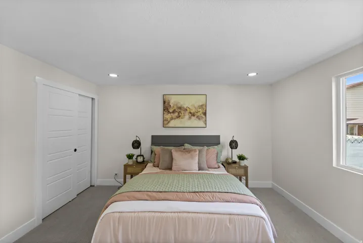 Recessed lighting, carpet flooring, sliding panel closet doors, and an exterior window