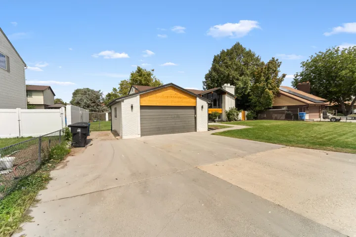 Detached garage with a dark gray overhead door and wood-finish accent paneling