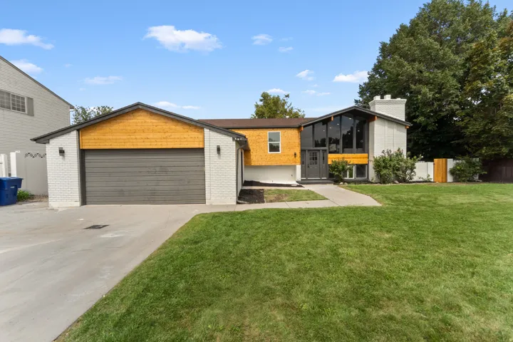 Contemporary-style exterior featuring a white brick facade and wood-finish accents