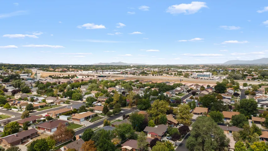 Residential neighborhood with mature trees and visible mountain range