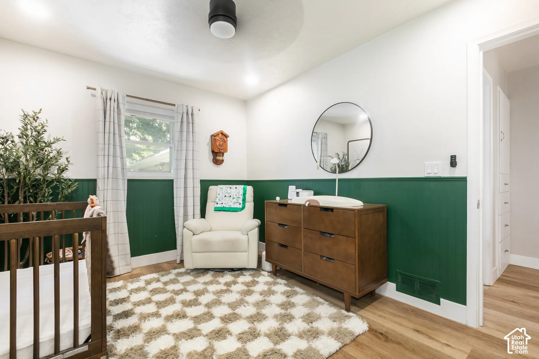 Wood-finish flooring, half-wall paneling, ceiling-mounted light fixture, recessed lighting, and a window with natural light