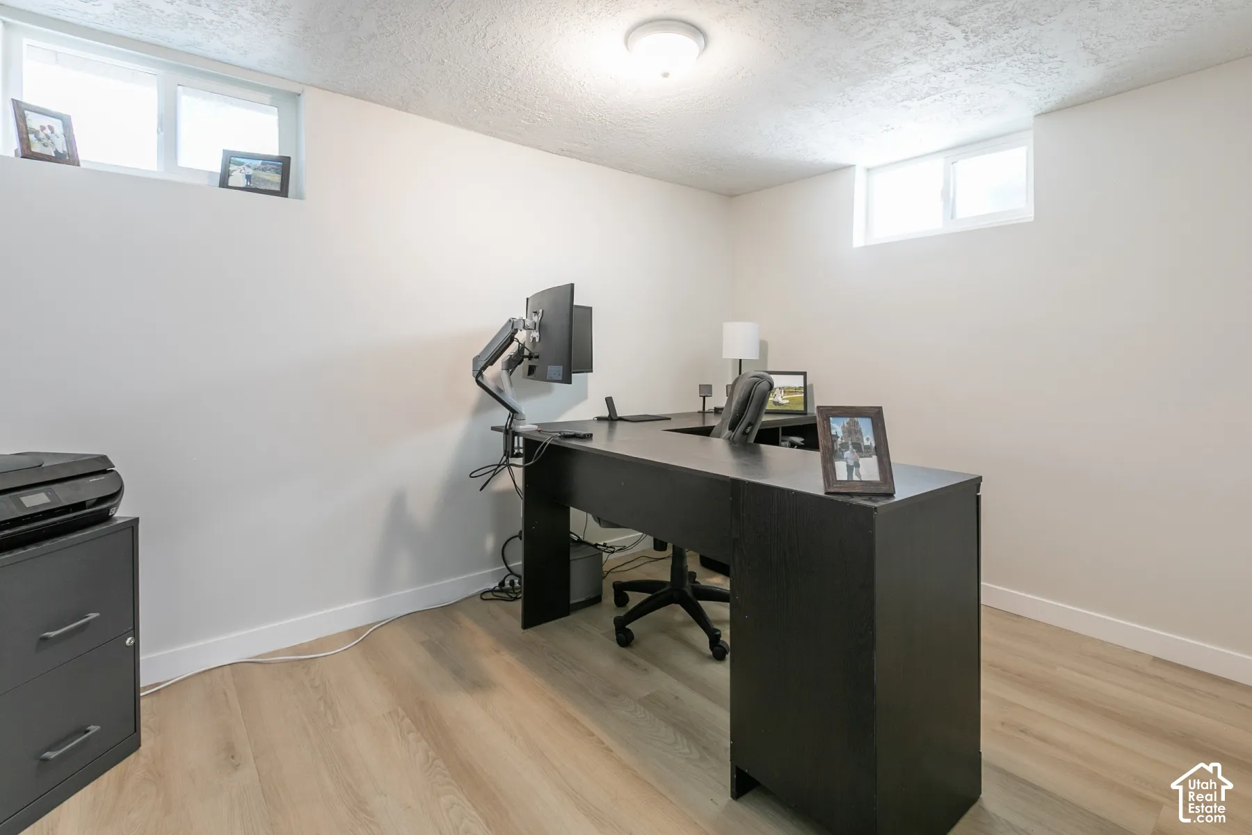 Light-toned wood-finish flooring, white walls, and two windows