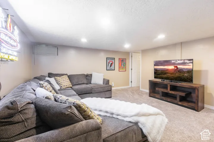 Recessed lighting, wall-to-wall carpeting, and a built-in entertainment console