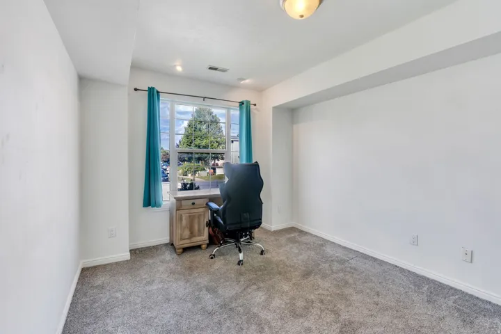Carpeted flooring, white trim, recessed lighting, and a window with a neighborhood backdrop