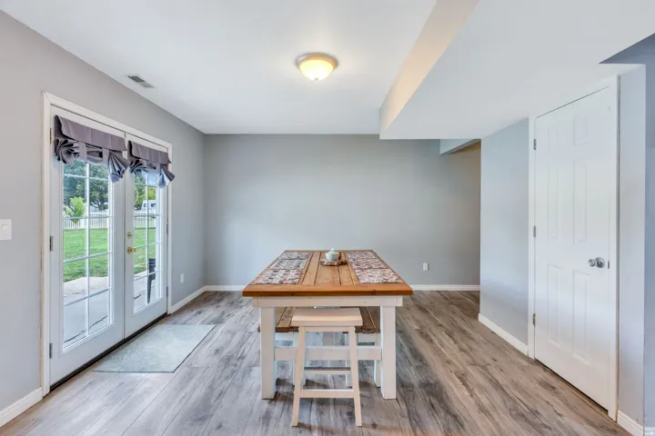 French doors with internal grilles, wood-finish flooring, recessed lighting, and a white paneled door