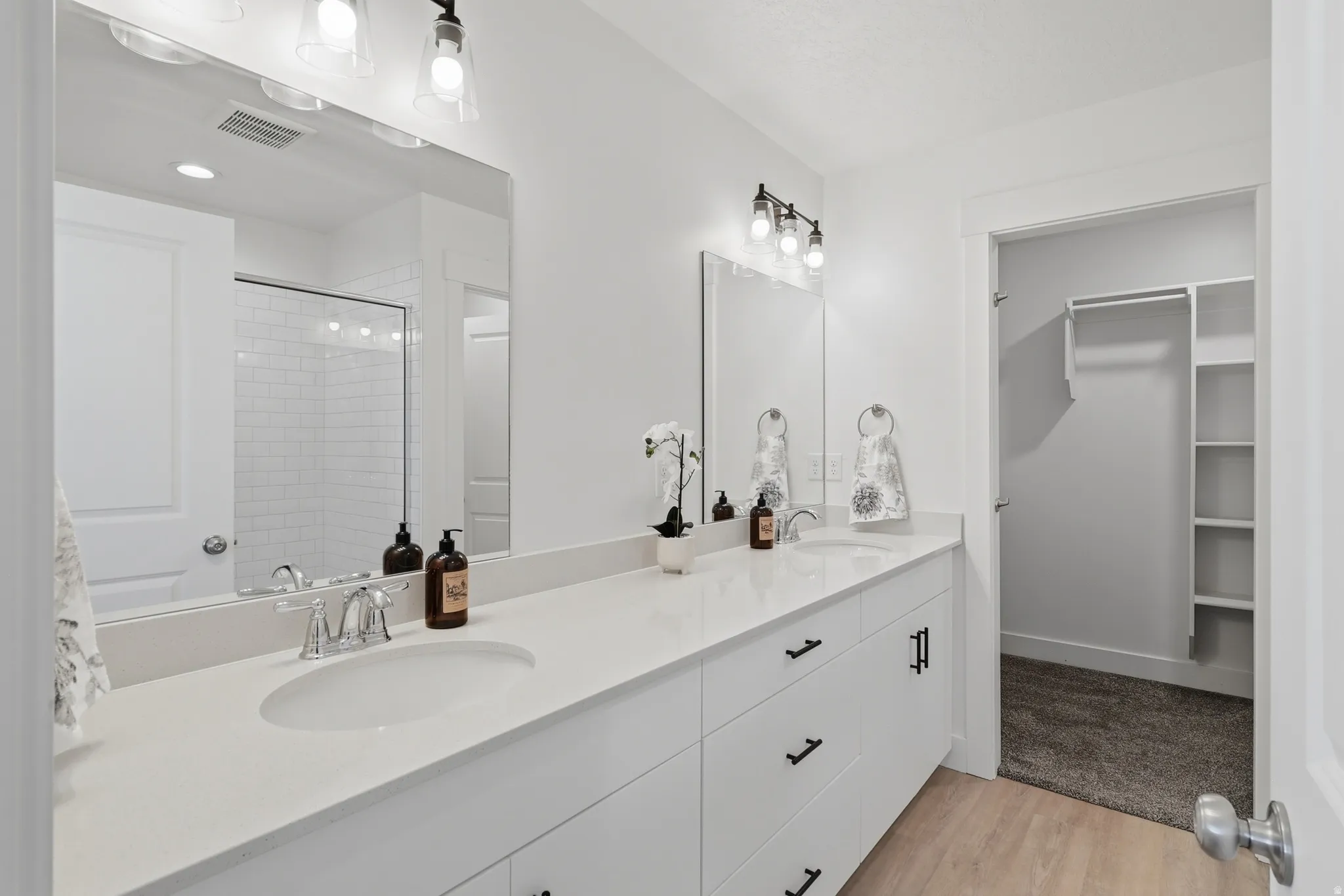 Dual vanity with integrated sinks, modern cabinetry, and chrome fixtures