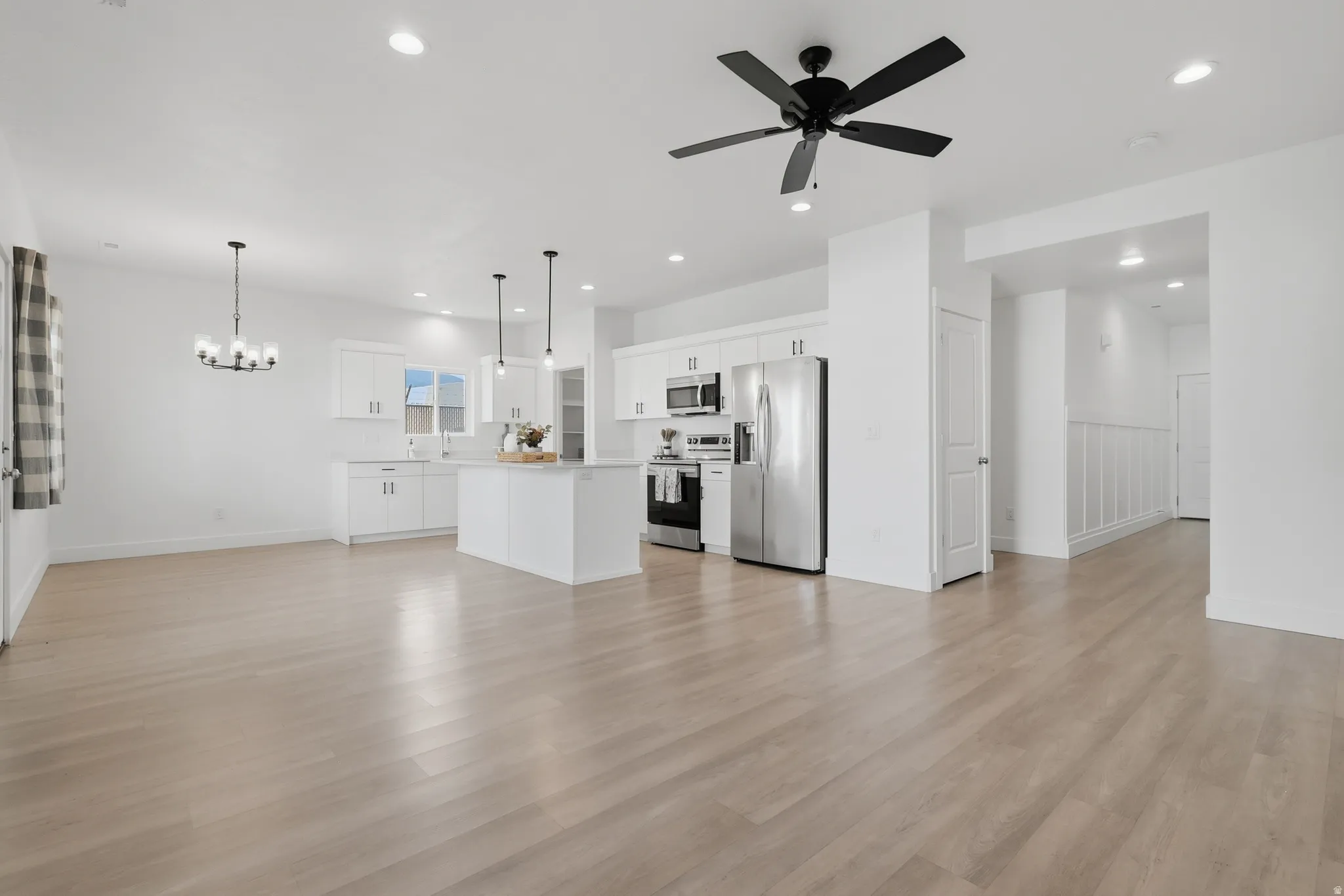 Open-concept living space featuring wood-finish flooring, recessed lighting, and a contemporary ceiling fan