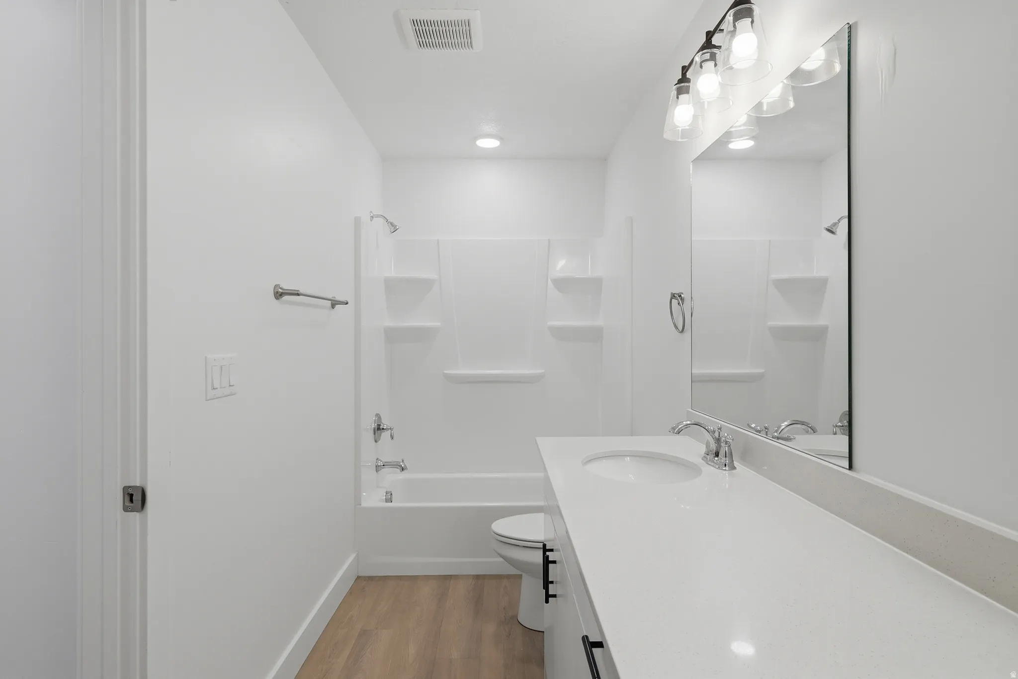 Vanity with integrated sink, chrome faucet, and expansive wall-mounted mirror
