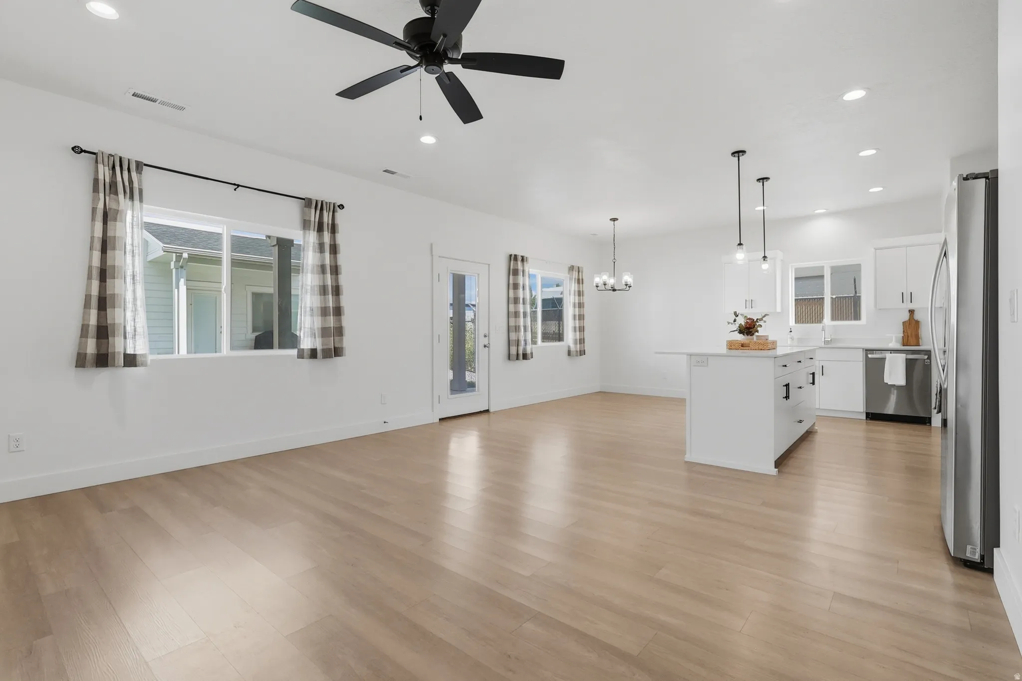 Open-concept living area featuring wood-finish flooring, recessed lighting, and a ceiling fan