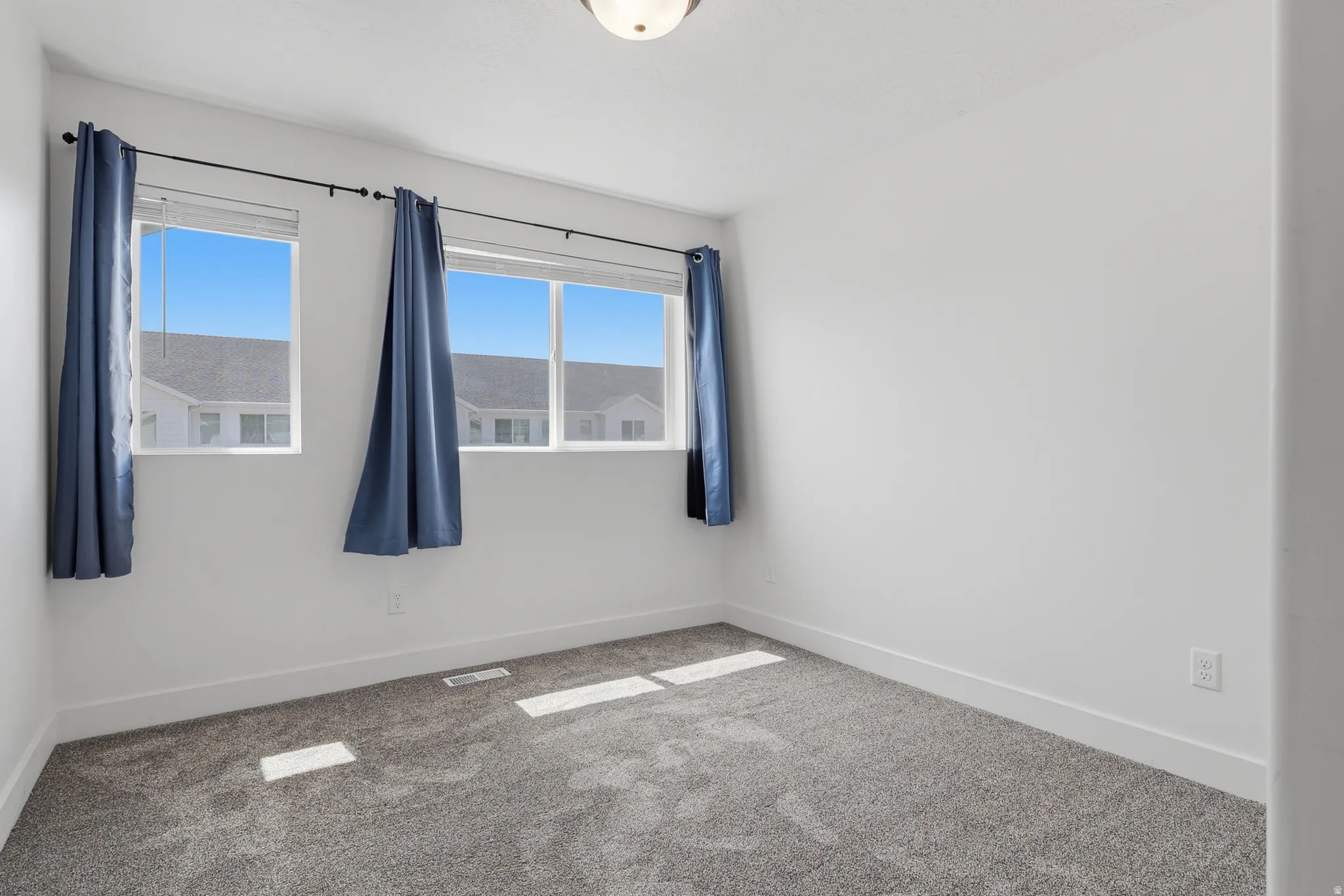 Neutral wall finishes, plush carpeting, and multiple windows