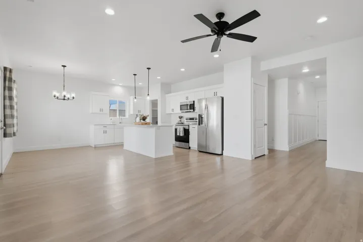 Open-concept living space featuring wood-finish flooring, recessed lighting, and a contemporary ceiling fan