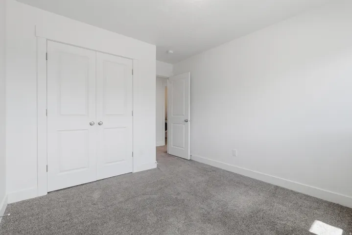 Neutral wall paint, gray carpet, and white trim