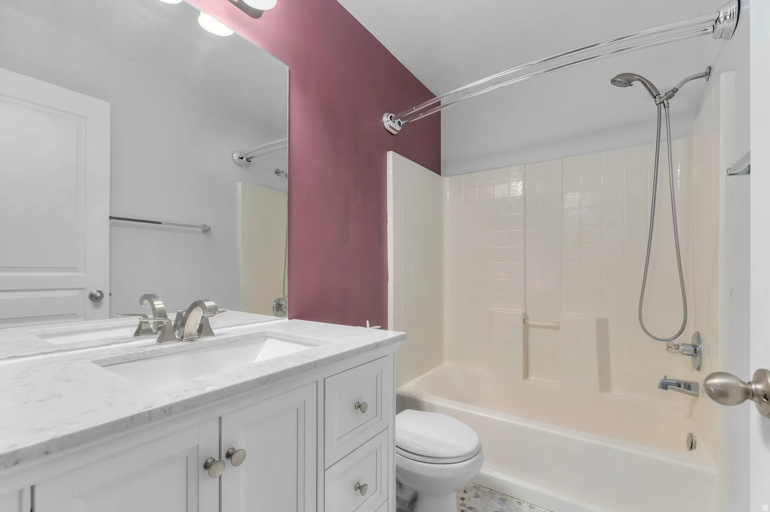 Bathroom featuring a white vanity with a light-colored countertop, an integrated sink, and brushed nickel hardware