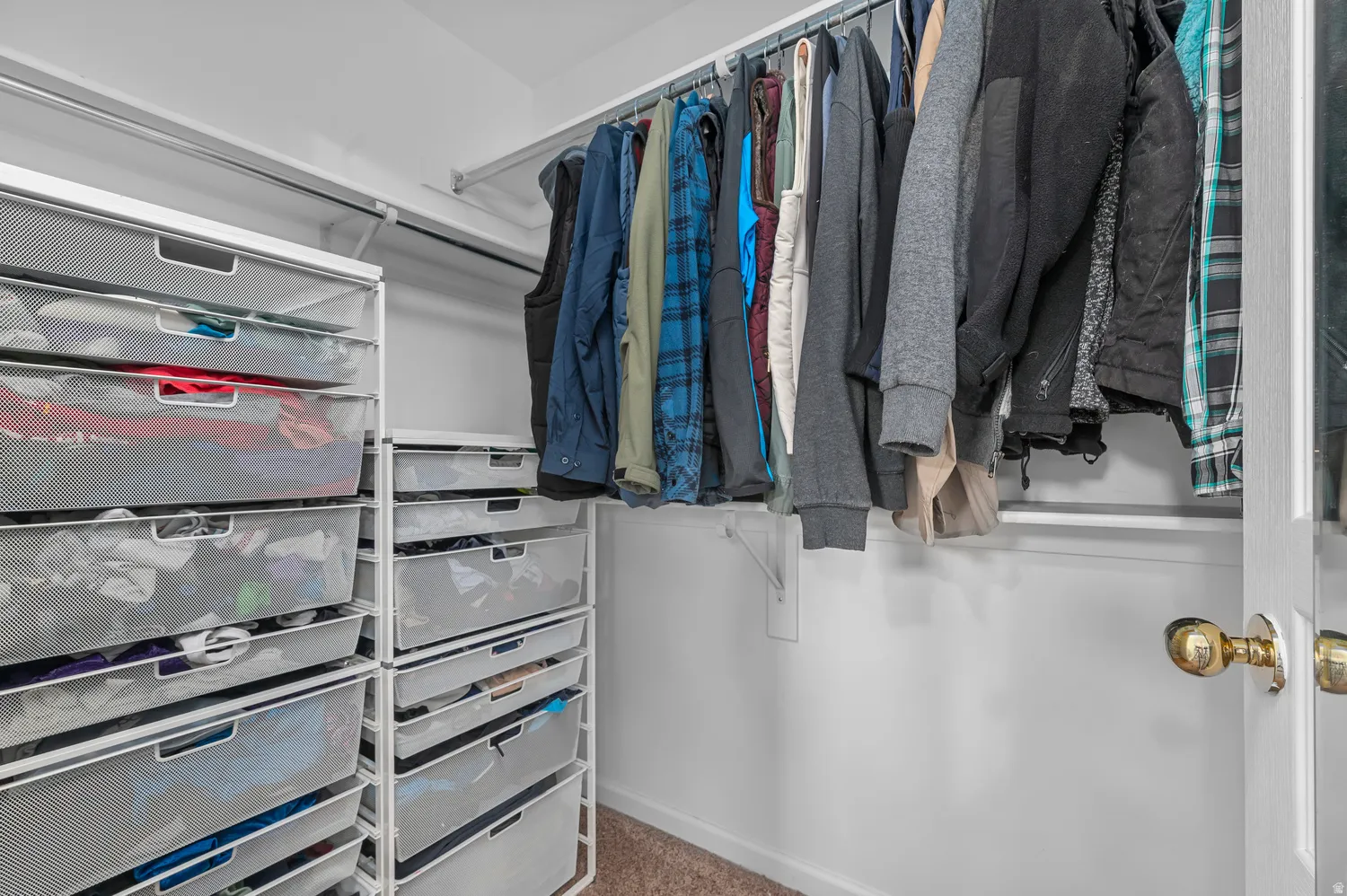 Built-in closet organization system with hanging rods and mesh drawers