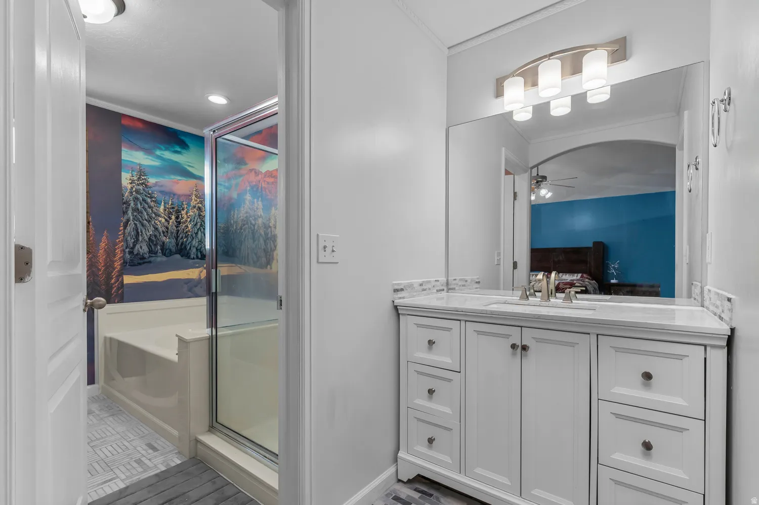 White vanity with brushed nickel hardware, marble-finish countertop, and undermount sink