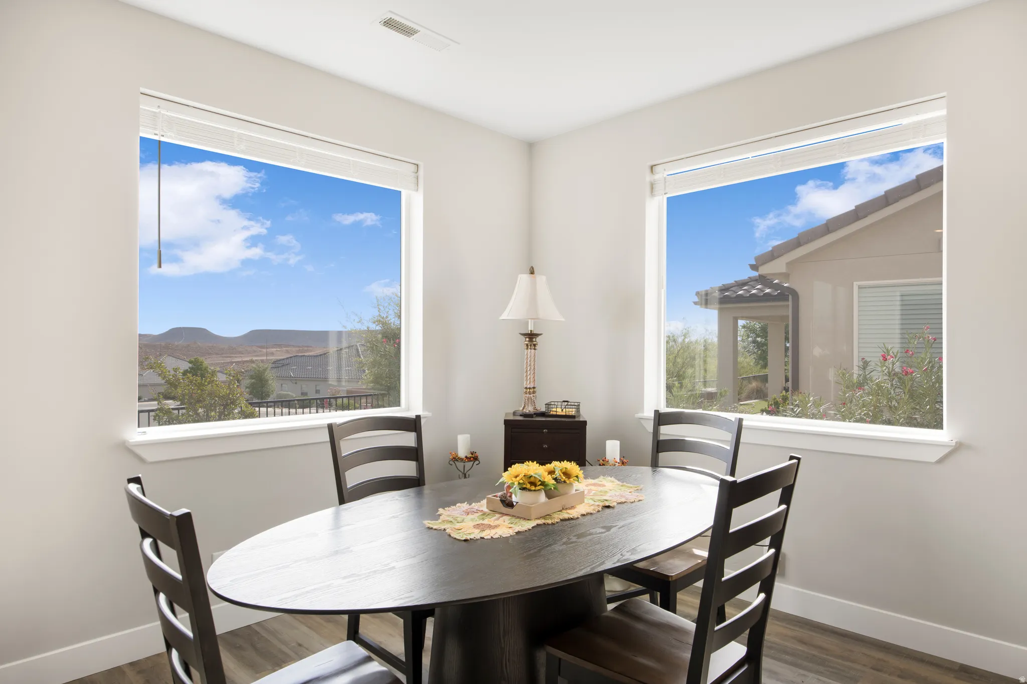 Dual windows with white trim, wood-finish flooring, and light-colored wall paint