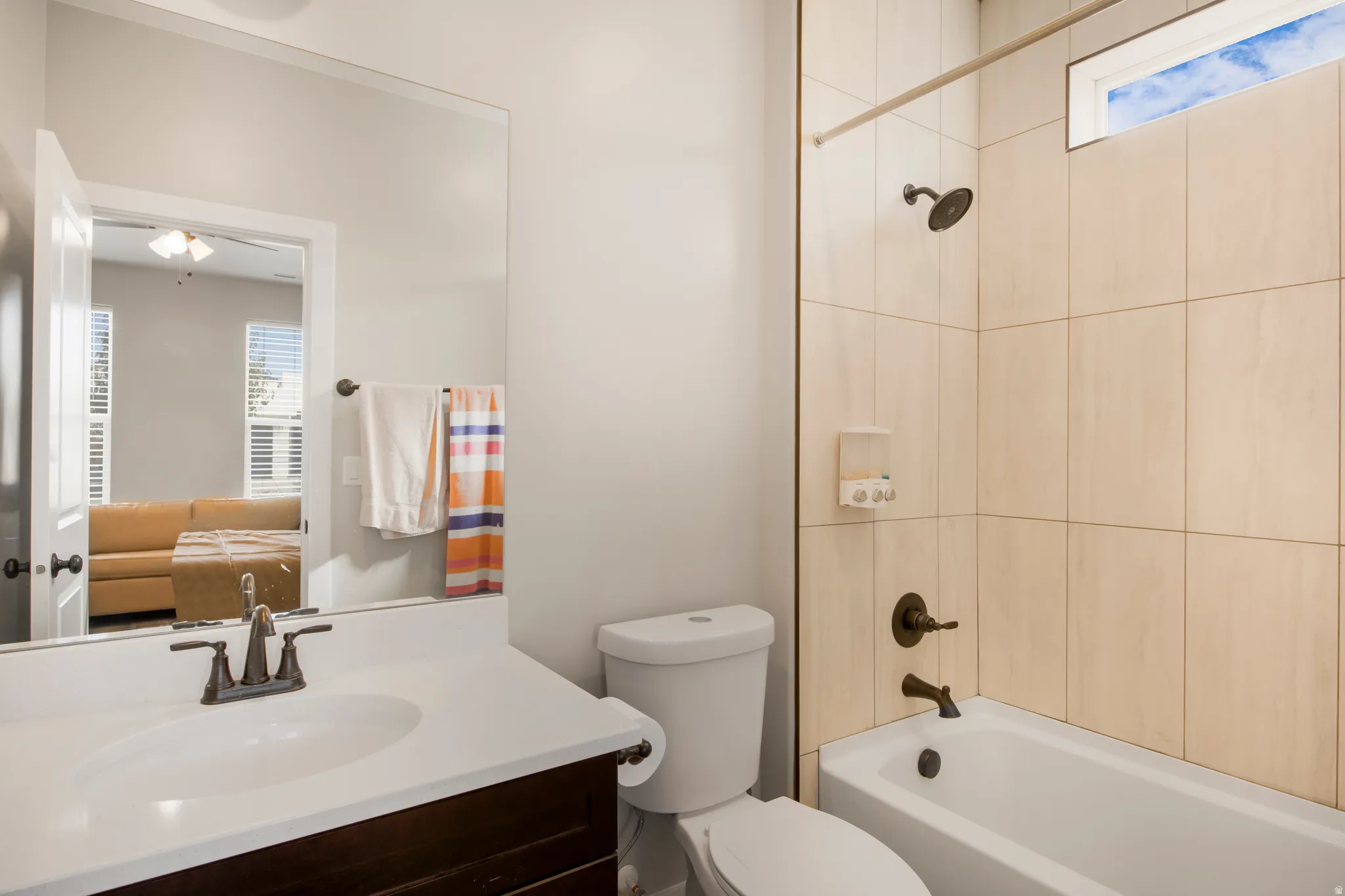 Bathroom featuring a tub/shower combination, white vanity countertop, and an integrated rectangular sink