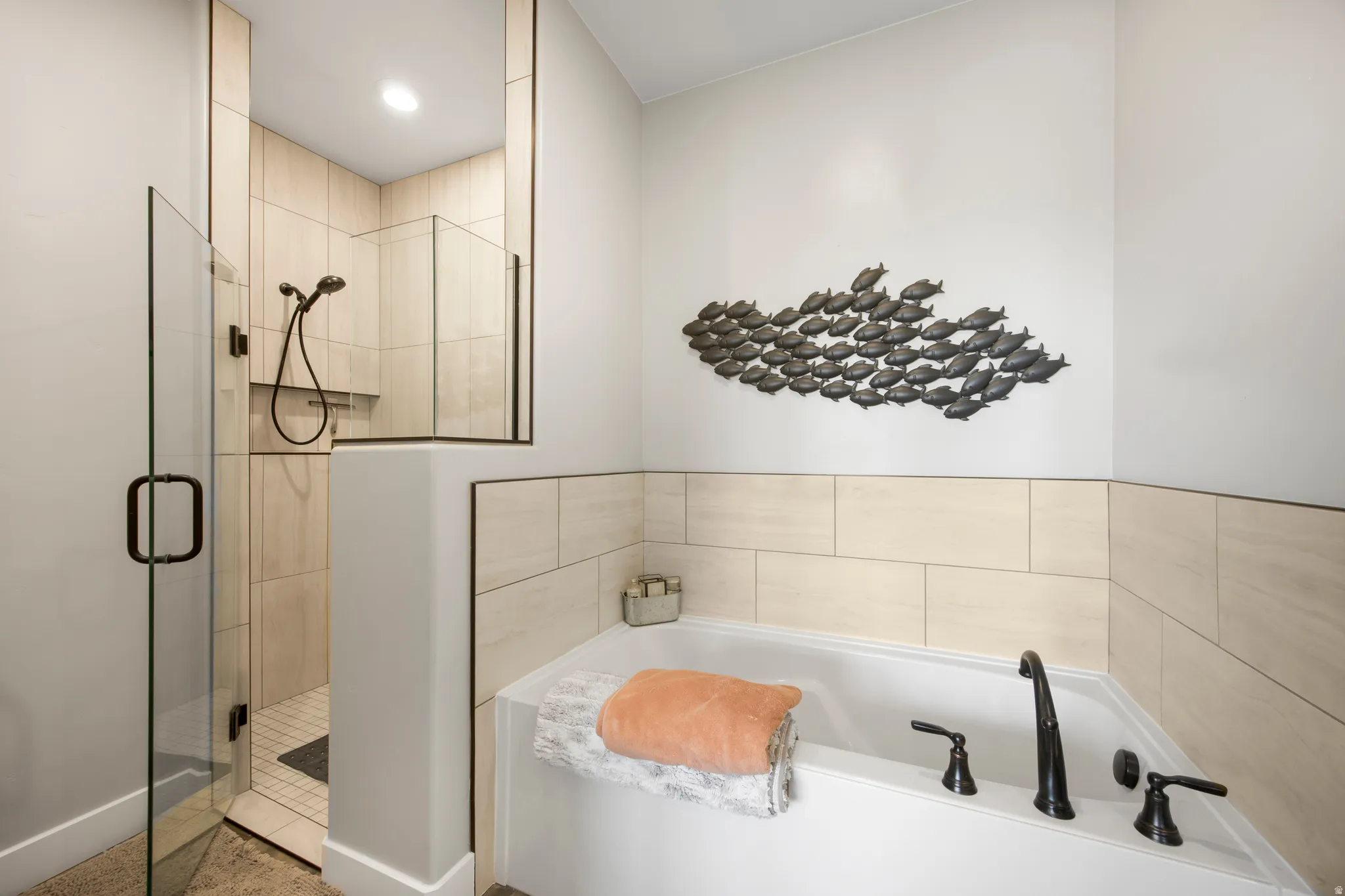 Soaking tub with dark bronze fixtures and tiled surround